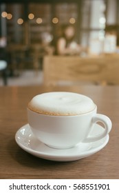 Cup Of Cappuccino Coffee With Foam Froth Cover On Top. Cafe Shop Bokeh Light Vintage Background.