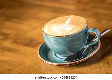 Cup of cappuccino coffee isolated on wooden background
