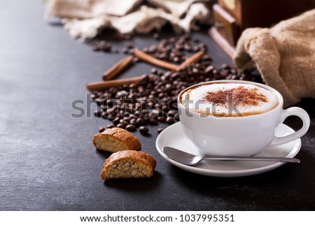 Cup of cappuccino coffee on dark table