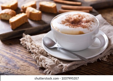 Taza de café capuchino sobre mesa de madera