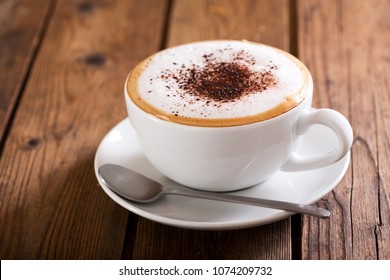 Чашка кофе капучино на деревянном столе