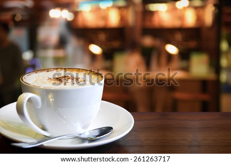 Cup of cappuccino with coffee shop background