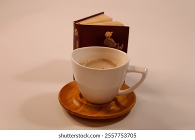 a cup of cappuccino coffee, a small antique book, a quiet moment of inspiration - Powered by Shutterstock