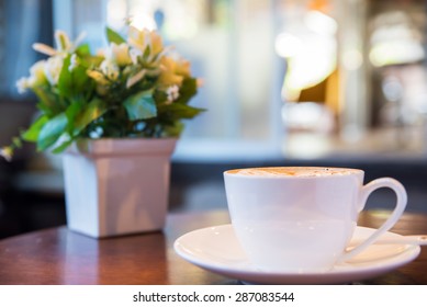 Cup of cappuccino with flower bouquet in coffee shop  - Shutterstock ID 287083544