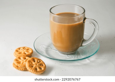 A cup of cappuccino on a saucer and some peanut butter cookies isolated on a white background.