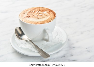 Cup of cappuccino on the table, coffee shop background. Marble texture