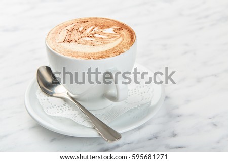 Cup of cappuccino on the table, coffee shop background. Marble texture