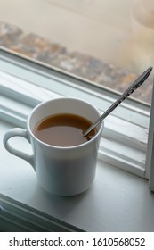 Cup Of Carmel Coffee In White Cup Sitting On Window Ledge