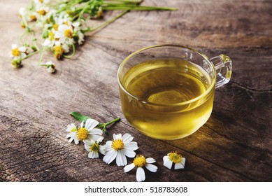 cup of chamomile tea with chamomile flowers on wooden planks on vintage tone