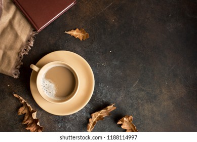 Cup Of Cocoa, Book And Autumn Leaves On Rustic Brown Background, Top View. Seasonal Cozy Autumn Hot Drink, Relax Concept.