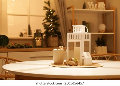 Cup of cocoa with lantern and Christmas decor on dining table in dark kitchen, closeup - Powered by Shutterstock