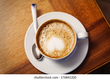 Cup Of Cofee From Top With Heart On The Foam, Copy Space. Coffee Cup In Coffee Shop - Vintage Style Effect Picture With Copy-space. Cup Of Coffee On The Corner From Above View.