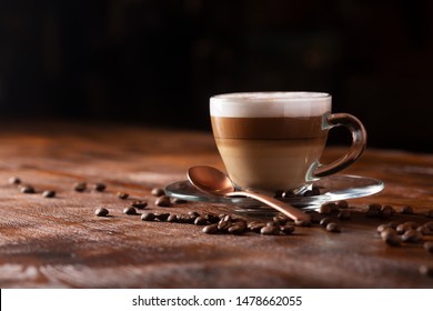 Taza de café con leche sobre un fondo oscuro. Leche caliente o cappuccino preparado con leche sobre una mesa de madera con espacio para copiar