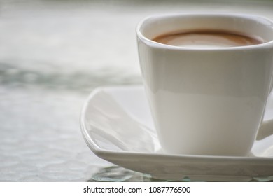 A Cup Of Coffe Put On The Glass Table In The Morning, Inside Hotel.