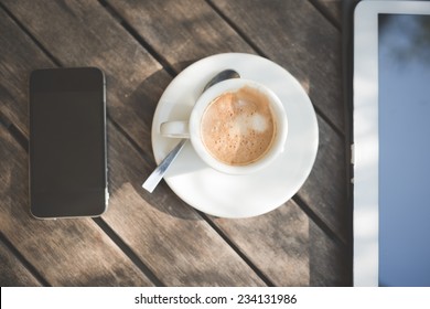 Cup Of Coffe Tablet And Smart Phone On Wooden Table