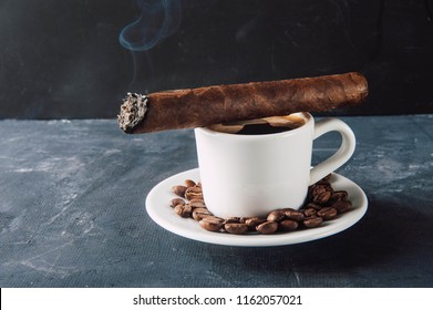 Cup of coffee, coffee beans, ashtray with cigar on dark background.Turk for coffee,aromatic coffee