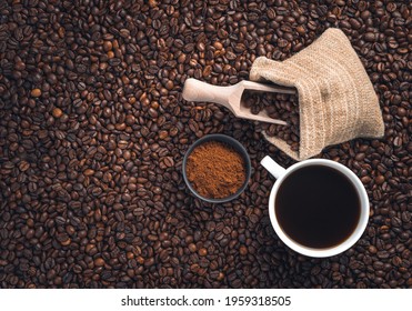 A Cup Of Coffee, Coffee Beans In A Bag And Ground Coffee On Coffee Beans. Top View.