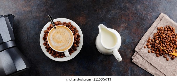 Cup of coffee and coffee beans on a dark background. Ingredients for making coffee with milk. Top view - Powered by Shutterstock