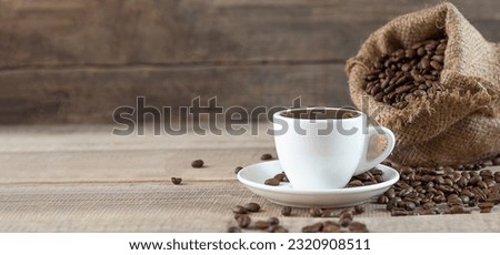 A cup of coffee. Coffee beans on a wooden background. Copy space. Banner