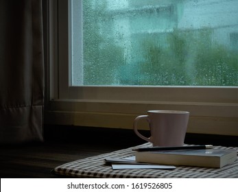 a cup coffee and book  on rainy day window background - Powered by Shutterstock