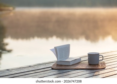 cup of coffee and book on wooden pier on summer lake - Powered by Shutterstock