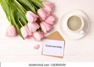 
A Cup Of Coffee, A Bouquet Of Flowers And A Card With The Words 