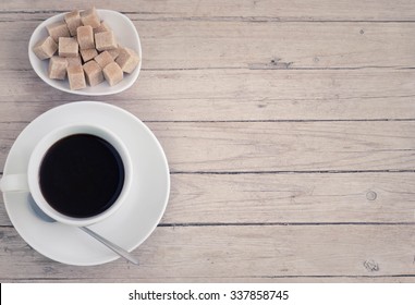 Cup Of Coffee With Brown Cube Sugar On A Wooden Table, Top View, Matte Effect.