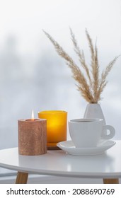 Cup Of Coffee With Burning Candles  On White Table By Window On Winter