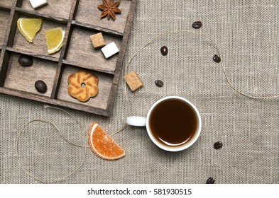 Cup of coffee, candies, coffee beans on linen background