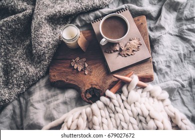 Cup Of Coffee And Candle On Rustic Wooden Serving Tray In The Cozy Bed With Blanket. Knitting Warm Woolen Sweater In The Autumn Weekend, Top View.