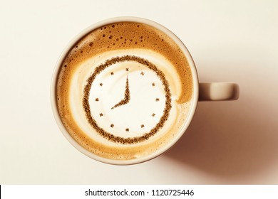 A Cup Of Coffee Cappuccino With A Clock Pattern From Cinnamon On Milk Foam