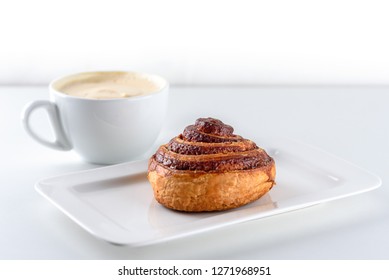 Cup Of Coffee And Cinnamon Roll Bun Pastry Over The White Background