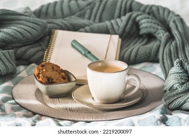 Cup of coffee and cookie on cozy bed. Warm wool sweater for a cozy autumn weekend, breakfast in bed, coffee break. Hygge concept. - Powered by Shutterstock