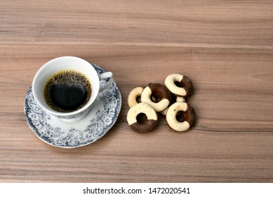 
cup of coffee with cookie on table with background