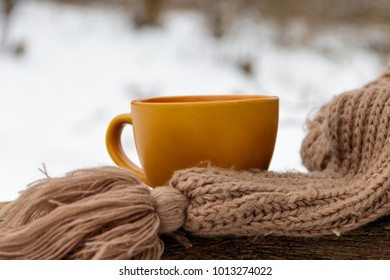 Cup of coffee and cozy knitted scarf on the background of the winter forest - Powered by Shutterstock