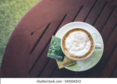 A Cup Of Coffee With Creamer And Sugar On The Wooden Table 