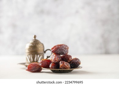 Cup of coffee and dry dates on saucer ready to eat for iftar time. Islamic religion and ramadan concept.