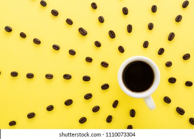 Cup of coffee espresso with sun rays of coffee beans on yellow background. Flat lay, creative design. Sunny morning & black coffee concept. - Powered by Shutterstock