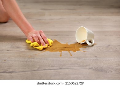 A cup of coffee fell on laminate, coffee spilled on floor. - Shutterstock ID 2150622729