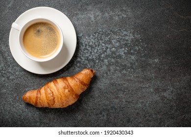 Cup Of Coffee And Fresh Croissant On Black Table