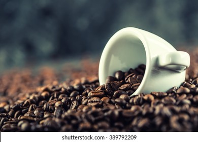 Cup of coffee full of coffee beans.