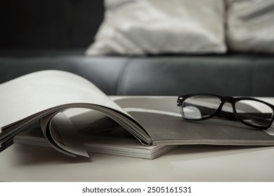 A Cup of Coffee, Glasses, and a Stack of Magazines on a White Tabletop