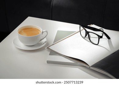 A Cup of Coffee, Glasses, and a Stack of Magazines on a White Tabletop