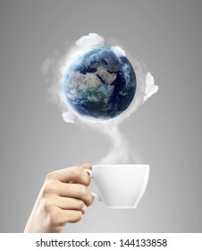 Cup Of Coffee In Hand With Earth