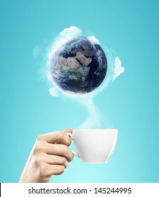 Cup Of Coffee In Hand With Earth