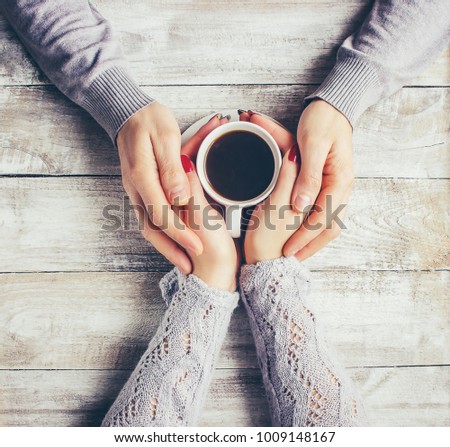 A cup of coffee in the hands of lovers. Selective focus.