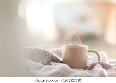 Cup of coffee and knitted sweater near window in morning. Space for text - Powered by Shutterstock - Get 15% off with code: PIKWIZARD15