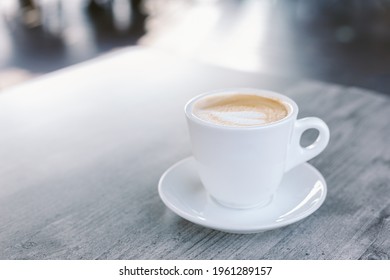 Cup of coffee with latte art on rustic wooden table in a street cafe. Place for text. - Powered by Shutterstock