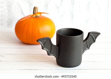 cup of coffee like a bat in  red paper packaging for Halloween. White background. Toy  and pumpkin  concepts.