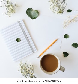 Cup Of Coffee With Milk, Sketchbook, Pencil, Green Leaves And Dried Flowers. Overhead View. Isolated On White. Flat Lay, Top View